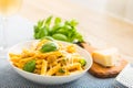 Pasta penne with chicken pieces mushrooms basil parmesan cheese and white wine. Italian food in white plate on kitchen Royalty Free Stock Photo