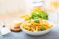 Pasta penne with chicken pieces mushrooms basil parmesan cheese and white wine. Italian food in white plate on kitchen Royalty Free Stock Photo