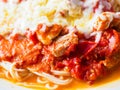 Pasta with pieces of chicken and tomatoes on a white plate. Spaghetti with tomato sauce and pieces of chicken or turkey. Italian Royalty Free Stock Photo