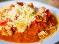 Pasta with pieces of chicken and tomatoes on a white plate. Spaghetti with tomato sauce and pieces of chicken or turkey. Italian Royalty Free Stock Photo