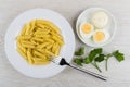 Pasta in plate, parsley, mayonnaise and boiled eggs in saucer