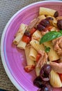 pasta plate, tortiglioni with tuna, cherry tomatoes and black olives, basil, Italian dish, ceramic plate Royalty Free Stock Photo