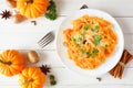 Autumn pasta with pumpkin cream sauce, top view scene over white wood