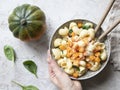 Pasta with pumpkin, spinach and cheese on shabby grey background