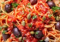 pasta puttanesca with olives, tomato sauce, anchovies and capers as background Royalty Free Stock Photo
