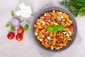 Pasta Radiatori with chicken, mushrooms, cherry tomatoes, feta cheese and tomato sauce on a light background. Royalty Free Stock Photo