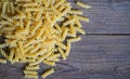 Pasta raw macaroni on wooden background, close up raw macaroni spiral pasta uncooked delicious fusilli pasta for cooking food - Royalty Free Stock Photo