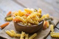 Pasta raw macaroni on wooden bowl background, close up raw macaroni spiral pasta uncooked delicious whole grain fusilli pasta for Royalty Free Stock Photo