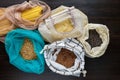 Pasta, rice, buckwheat and groats in reusable cotton bags on the black wooden table in the kitchen. Zero Waste concept. Top view. Royalty Free Stock Photo