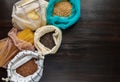 Pasta, rice, buckwheat and groats in reusable cotton bags on the black wooden table in the kitchen. Zero Waste concept. Top view. Royalty Free Stock Photo