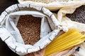 Pasta, rice, buckwheat and groats in reusable cotton bags on the black wooden table in the kitchen. Zero Waste concept. Top view. Royalty Free Stock Photo