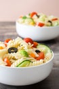 Pasta salad in a bowl on rustic wooden background Royalty Free Stock Photo