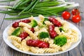 Pasta salad with broccoli and grilled sausages decorated with d Royalty Free Stock Photo