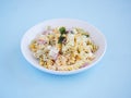 pasta salad plate with corn, cheese and jam, parsley on top, horizontal view on a blue surface Royalty Free Stock Photo