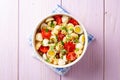 Pasta salad with quail eggs, mozzarella, cherry tomatoes and capers in bowl on purple wooden background Royalty Free Stock Photo