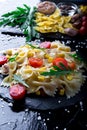 Pasta salad in slate plate with tomatoes cherry, tuna, corn and arugula. ingredients. Italian food. Royalty Free Stock Photo