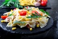 Pasta salad in slate plate with tomatoes cherry, tuna, corn and arugula. ingredients. Italian food. Royalty Free Stock Photo