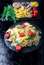 Pasta salad in slate plate with tomatoes cherry, tuna, corn and arugula. Top view. ingredients. Italian food. Royalty Free Stock Photo