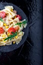 Pasta salad in slate plate with tomatoes cherry, tuna, corn and arugula. Top view. Italian food. Copy space. Royalty Free Stock Photo