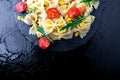 Pasta salad in slate plate with tomatoes cherry, tuna, corn and arugula. Top view. Italian food. Copy space. Royalty Free Stock Photo