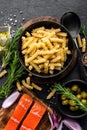 Pasta, salmon fish and ingredients for cooking on black background, top view. Italian food Royalty Free Stock Photo