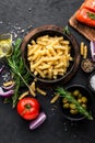 Pasta, salmon fish and ingredients for cooking on black background, top view Royalty Free Stock Photo