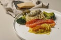 Pasta with salmon and various vegetables with pesto sauce. Close-up. Italian cuisine. Mediterranean healty and tasty food