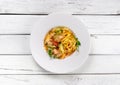 Pasta with salmon, zucchini and tomatoes in a creamy sauce on white wood background. Top view Royalty Free Stock Photo