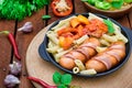 Pasta with sausages and lecho. Wooden rustic background. Selective focus. Top view Royalty Free Stock Photo