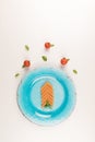Pasta in a shape of an arrow, pasta with tomatoes and basil in turquoise blue plate on white background