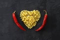 Pasta in the shape of a heart on a black background. With red hot chili peppers. Royalty Free Stock Photo