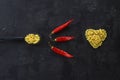 Pasta in the shape of a heart on a black background. With red hot chili peppers. Royalty Free Stock Photo