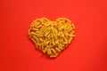 Pasta in the shape of a heart on a red background. Royalty Free Stock Photo