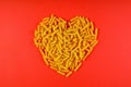 Pasta in the shape of a heart on a red background. Royalty Free Stock Photo