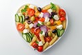 Pasta in the shape heart salad with tomatoes, cucumbers, olives, mozzarella and red onion Greek style Royalty Free Stock Photo