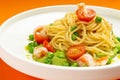Pasta with shrimp and tomato in a plate on an orange background. Royalty Free Stock Photo