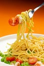 Pasta with shrimp and tomato in a plate on an orange background. Royalty Free Stock Photo