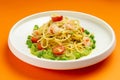 Pasta with shrimp and tomato in a plate on an orange background. Royalty Free Stock Photo