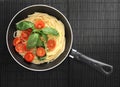 Pasta spaghetti with cherry tomatoes and basilikum in the pan Royalty Free Stock Photo