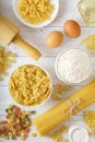 Pasta with spaghetti and ingredients for pasta on white wood background.