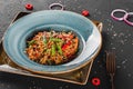 Pasta spaghetti with sauce, stew vegetables and seeds in plate on dark stone table.Vegetarian noodles, Italian food Royalty Free Stock Photo