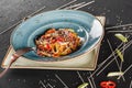 Pasta spaghetti with sauce, stew vegetables and seeds in plate on dark stone table.Vegetarian noodles, Italian food Royalty Free Stock Photo
