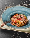 Pasta spaghetti with sauce, stew vegetables and seeds in plate on dark stone table.Vegetarian noodles, Italian food Royalty Free Stock Photo