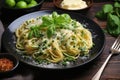 Pasta spaghetti with zucchini, green peas and cream sauce on black stone background. Vegetarian vegetable pasta. Zucchini noodles