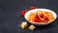 Pasta penne with tomato sauce, fresh basil, roasted tomatoes and parmesan on the dark background