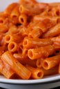 Pasta with tomato sauce on whit plate, close up