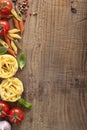 Pasta tomatoes basil frame on wooden background Royalty Free Stock Photo