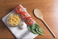 Pasta with tomatoes, basil, garlic and a wooden spoon Royalty Free Stock Photo