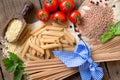 Pasta, tomatoes, basil and parsley on wooden background Royalty Free Stock Photo
