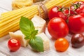 Pasta, tomatoes, basil on wooden table Royalty Free Stock Photo